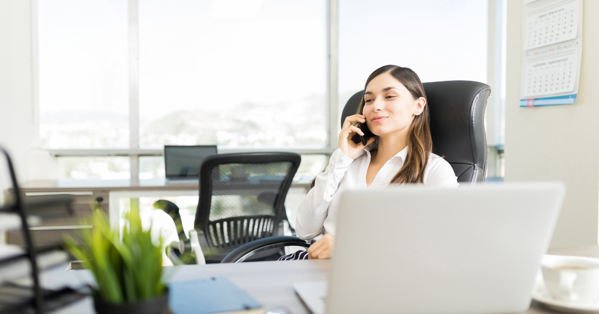 agente inmobiliario realizando una llamada a un cliente desde su oficina
