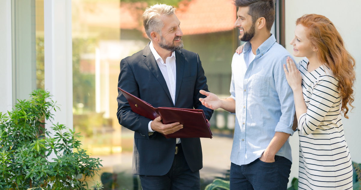 Asesor inmobiliario hablando con dos clientes