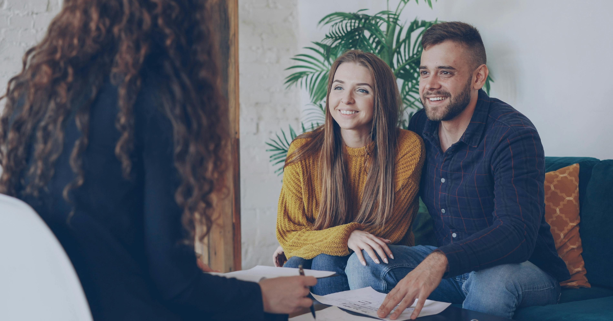 asesor inmobiliario hablando con dos clientes